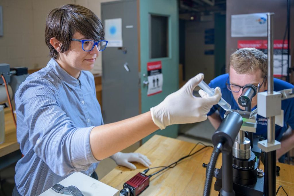 Two engineers examining aerospace components and testing equipment in a research facility.